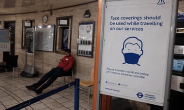 A sign advising the use of face coverings for commuters at Piccadilly Circus underground station in London.