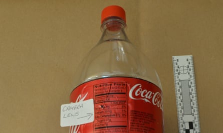 A Coca-Cola bottle with a small hole in its side for a camera
