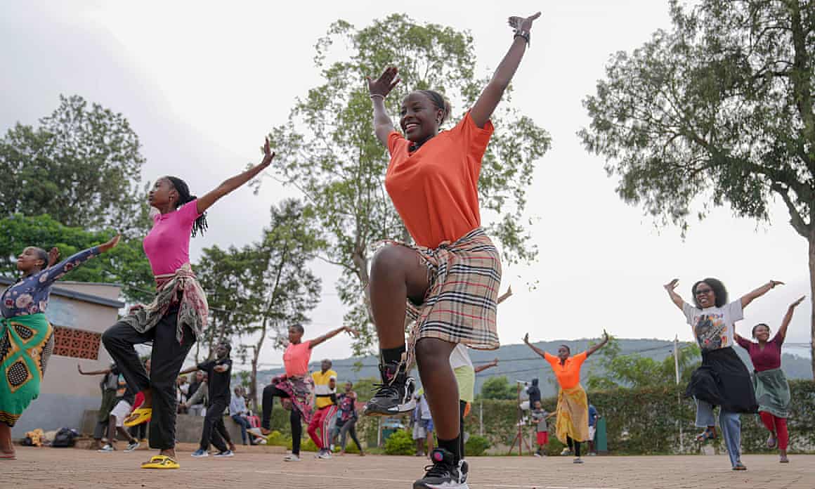 Women standing on one leg and raising their hands in the air during a dance