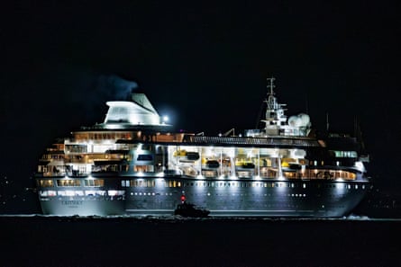 The Odyssey cruise ship, brightly lit, sails at night leaving Belfast Harbour
