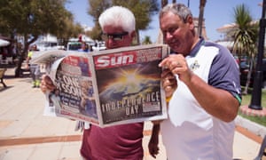 British expats read in a copy of the Sun in Malaga, Spain.