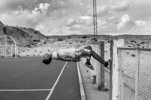 A young man bounces off a fence-post in a soccer field in Gafsa, a region crucial to the Tunisian economy for its phosphate mines and marked by high youth unemployment. Umm-Al-Arais, Gafsa, Tunisia, 17 October 2015