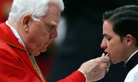 A US cardinal, Bernard Law, gives communion to a young seminarian in 2005. Law was forced to resign over sexual abuse scandals in his Boston archdiocese