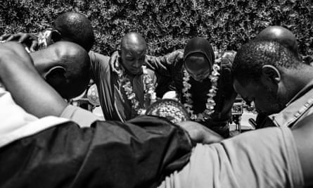 A group of riders say a prayer before departing in convoy to attend a colleague’s wedding