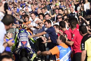 Movistar Yamaha’s Valentino Rossi is congratulated by spectators on arrival to his pit garage after the race.