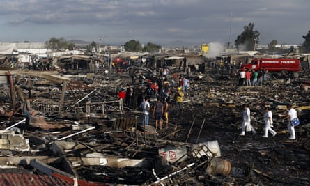 Firefighters and rescue workers walk through the scorched ground of Mexico’s best-known fireworks market after the explosion.