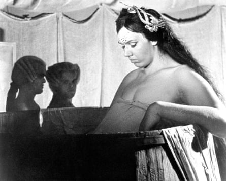Black and white still of the female giant and two men in 18th-century wigs