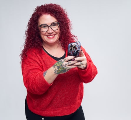 Smiling woman holding a mobile phone in front of her in both hands