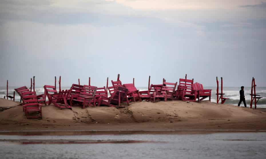 A man walks past tied up chairs at the Miramar beach as Hurricane Ingrid approaches the coast in Ciudad Madero, Mexico, in 2013.