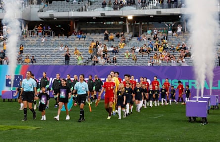 The teams walk out in front of an empty stand