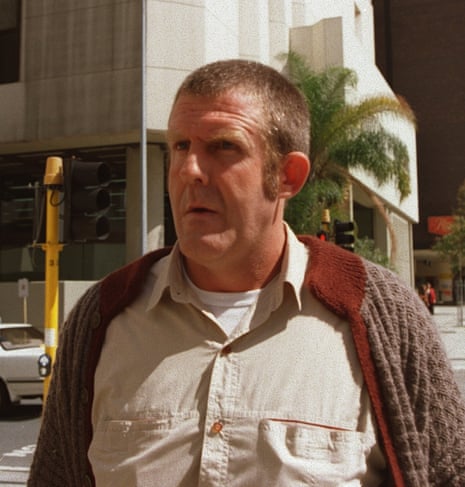 A man with short hair in a light shirt and cardigan.