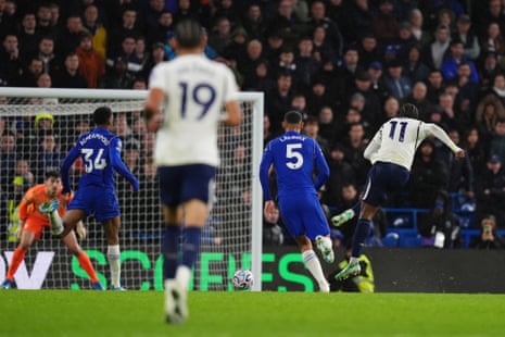 Tottenham's Mathys Tel strikes the ball mid-air as Chelsea players chase behind