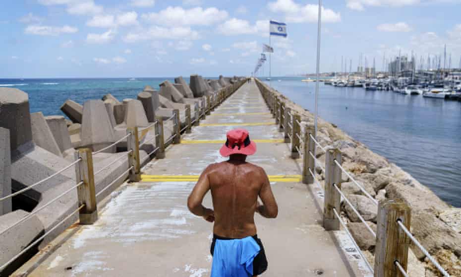 A jogger runs along a marina in Herzliya, Israel.