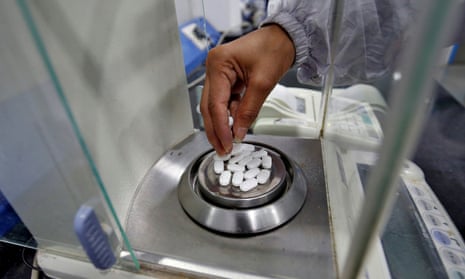 A pharmacist in Ahmedabad, India, weighs tablets.