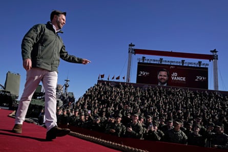 man smiles while walking and looking at crowd of military service members