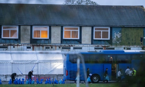 Asylum seekers board a bus to leave the Manston airfield holding facility, a former RAF base, on 2 November. 