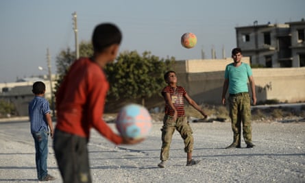 Syrian children play football with Free Syrian Army members.