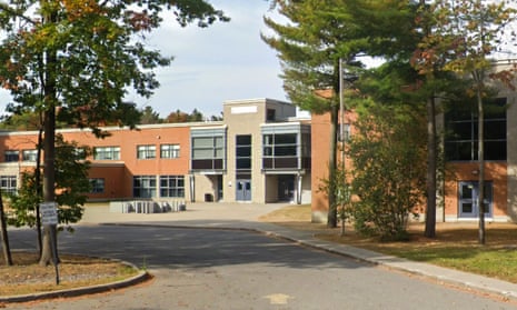 Two trees frame an orange and grey building.