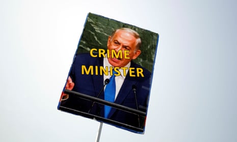 A protester holds a sign during a rally calling upon Benjamin Netanyahu to step down. The Israeli PM has been accused of bribery in two separate cases.