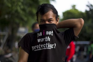 A man covers his face with a shirt instead of a face mask while in a queue to get the Takjil, food for breaking the Ramadan fast, in central Jakarta.