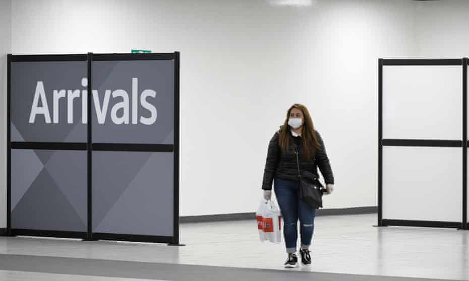 a lone woman emerges from arrivals hall