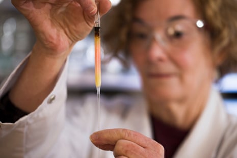 Biogeochemistry lab manager Janet Hope from the ANU research school of earth sciences holds a vial of coloured porphyrins (pink coloured liquid), believed to be some of the oldest pigments in the world.