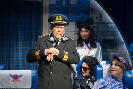 Ryecart in uniform stands in the aisle of the plane.