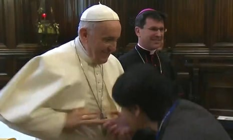 Pope Francis recoils from a worshipper attempting to kiss his ring.