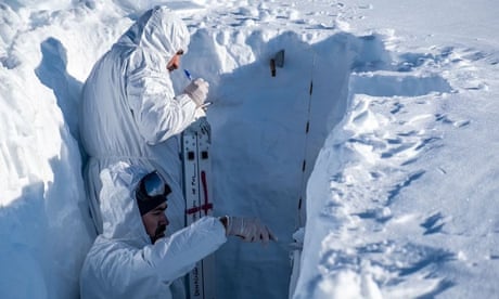 Investigadores raspando hielo en una trinchera en la Antártida.