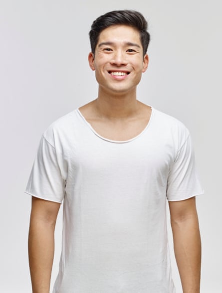 A young man wearing a white cotton tee, with raw cut sleeves and collar.