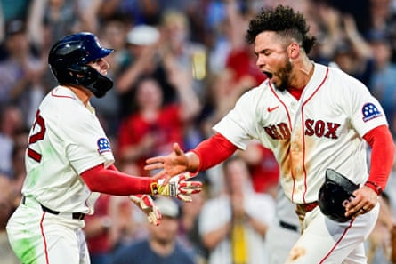 A pair of Boston Red Sox teammates exchange high fives after a home run.
