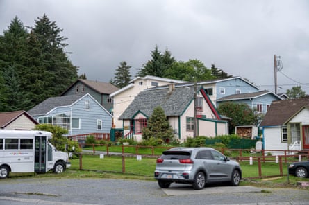 Blue and pink houses with cars in front