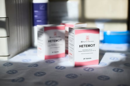 A closeup of three white and pink packets of medication labelled ‘Hetemcit’.