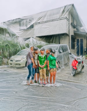 A group of people covered in a plastic sheet posing for a photograph