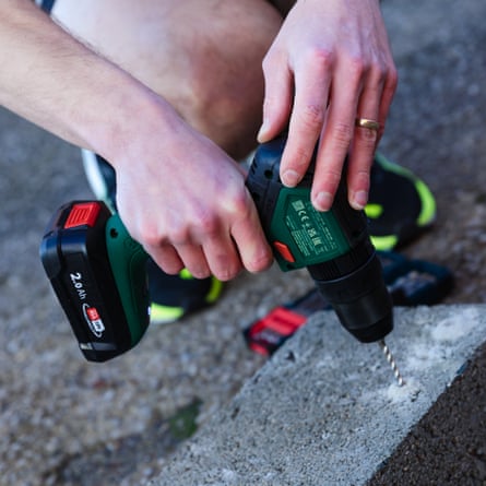 A close up of a Bosch Universal Impact 18V-60 Combi Drill drilling into a concrete brick.