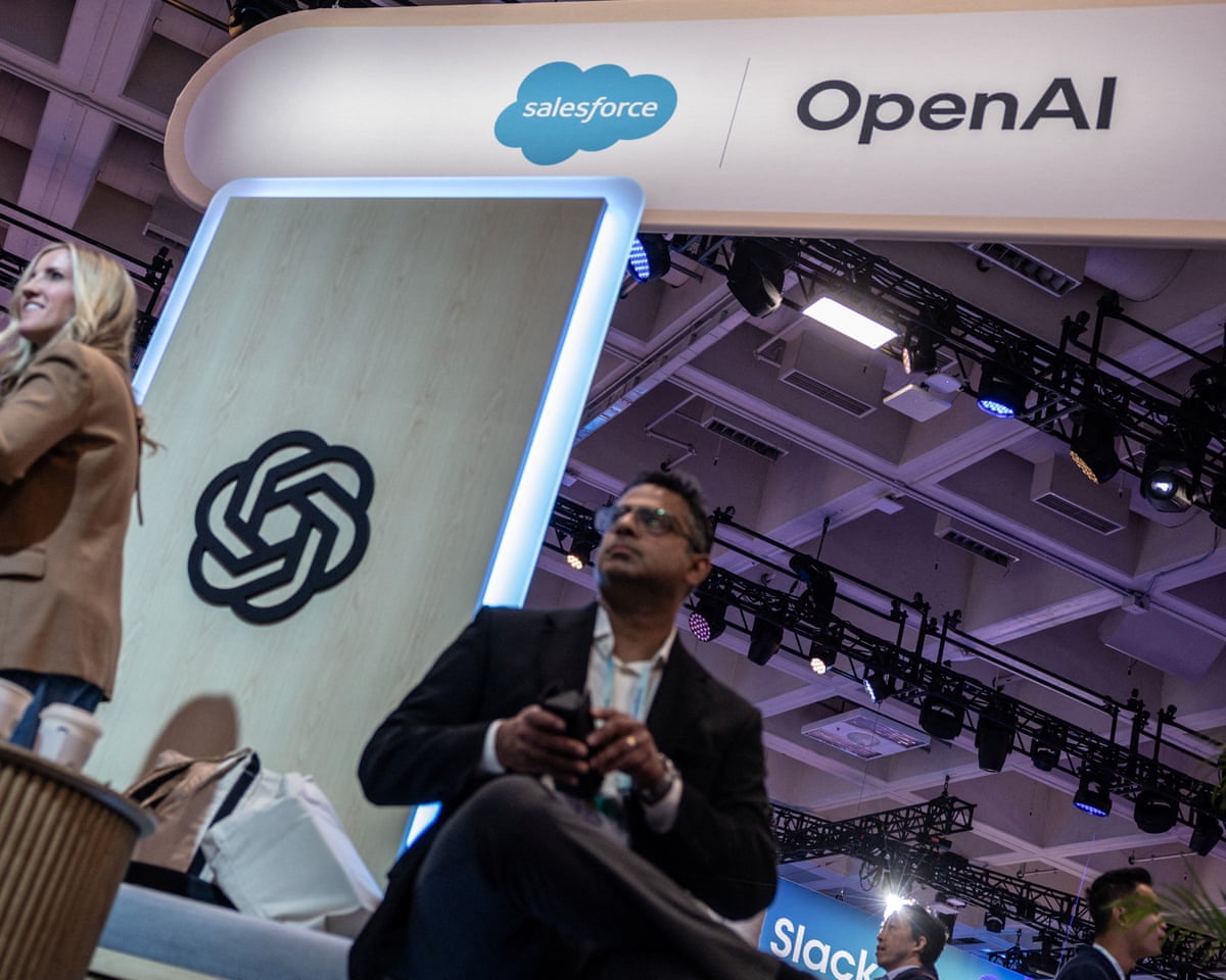 OpenAI booth at a technology conference beneath Salesforce signage