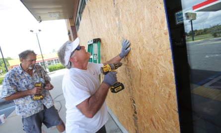 Mikes Jones (front) and Dan Steele boarded up a gas station Tuesday in preparation for Hurricane Michael in Panama City, Florida.