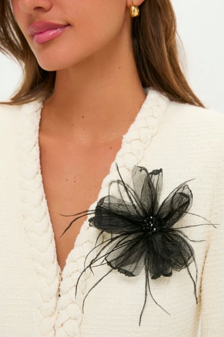 close-up of black flower brooch pinned on white sweater