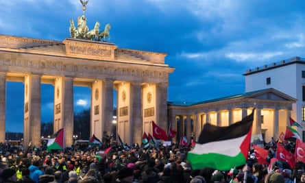 Protests in front of the Brandenberg Gate, Berlin, wave Palestinian flags