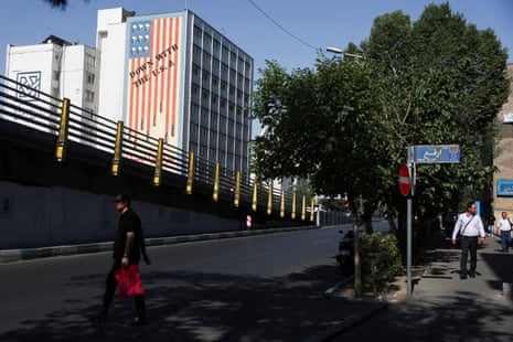 A man walks near an anti-US mural on a building in Tehran, Iran.