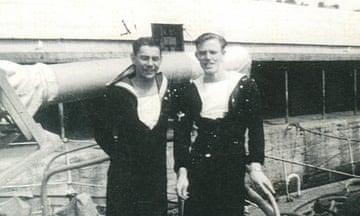 Two second world war-era sailers pose onboard a ship.