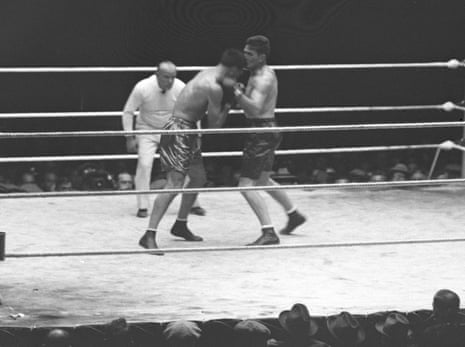 Gene Tunney throws a left hook at Jack Dempsey as referee Tommy Reilly watches