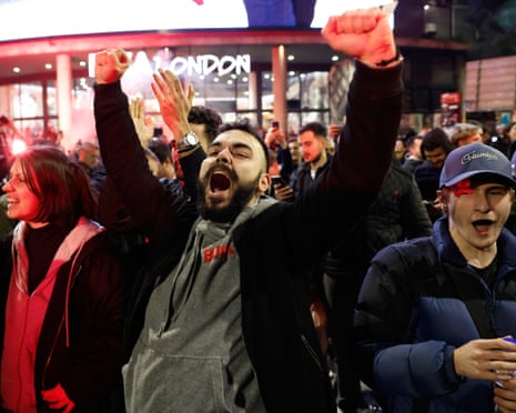 Crowd in Belgrade cheers at night after election result, a man raising his fists