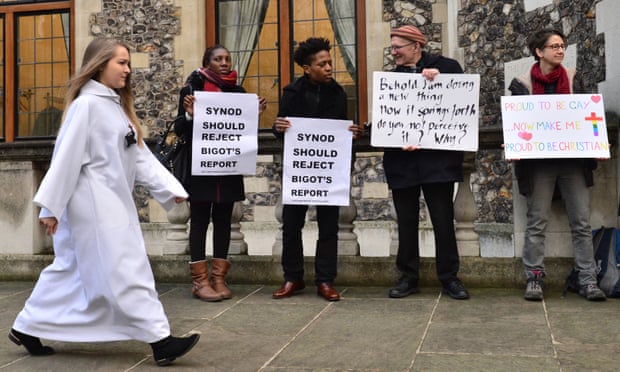 A delegate walks past activists from the Lesbian and Gay Christian Movement outside the General Synod at Church House in London.