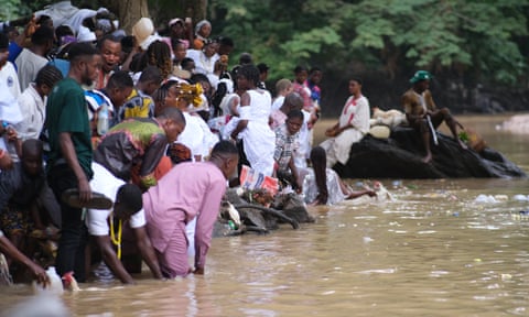 Worshippers gather at the edge of the Osun River offering gifts and prayers to the goddess Osun