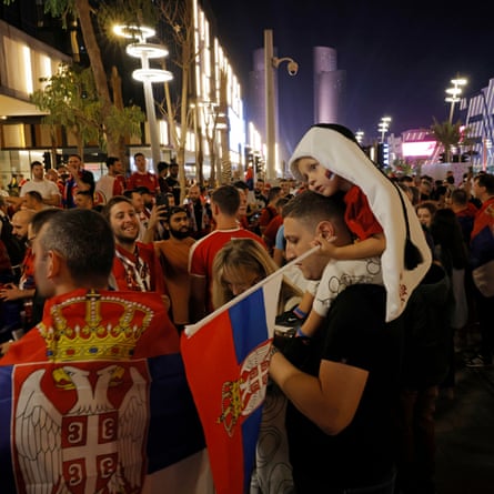 Welcome to Lusail: Lego-city of the gods and one of the strangest places on earth | World Cup 2022 6 A young Serbian boy, wearing a head-dress shaped to look like the tournament mascot La’eeb, looks tired on his father’s shoulders as Serbian fans gather outside the McDonalds on Lusail Boulevard before the Brazil v Serbia World Cup match.