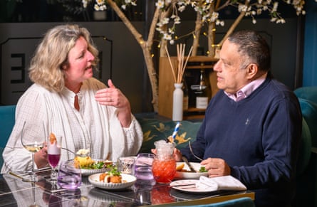 A woman and man facing each other across a restaurant table