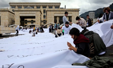 A group of people participate in an artistic intervention lead by the Colombian artist Doris Salcedo in Bogota Tuesday.