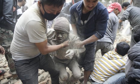 People free a man from the rubble of a destroyed building in Kathmandu after the earthquake hit