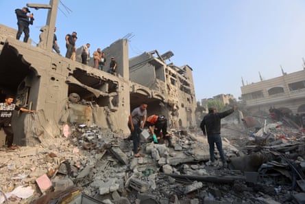 Los palestinos buscan supervivientes entre los escombros de un edificio alcanzado por un ataque aéreo israelí en Khan Yunis, al sur de la Franja de Gaza.